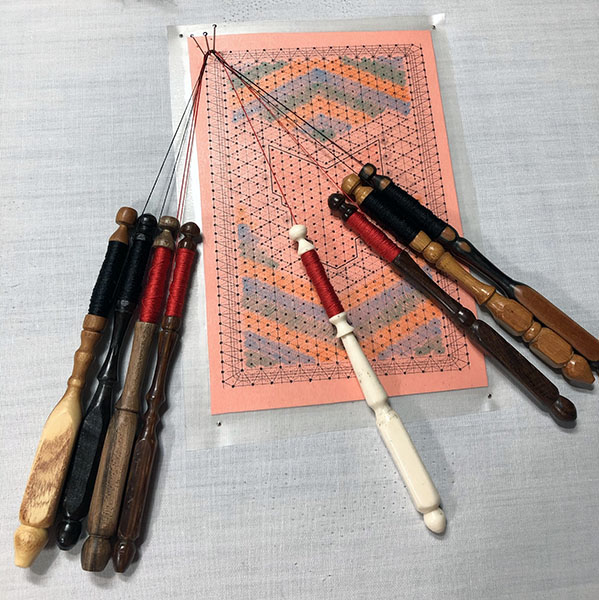 Starting the fox bobbin lace pattern with a few bobbins