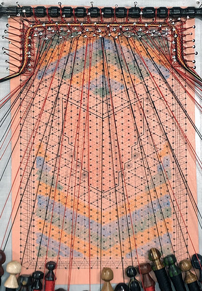 wood spindle, threads, fox bobbin lace pattern