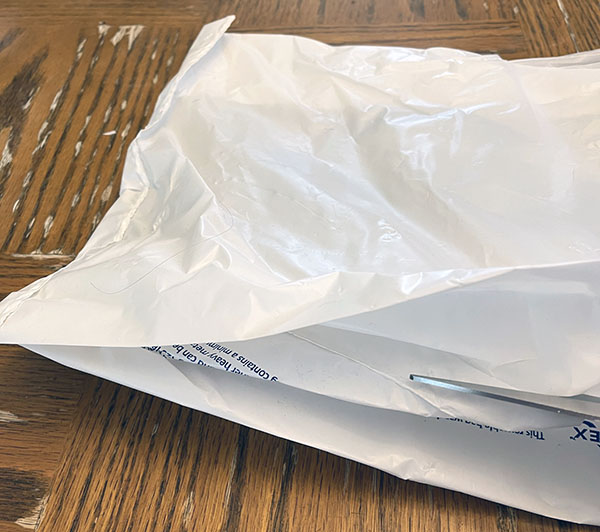 cutting the bottom of the plastic bag