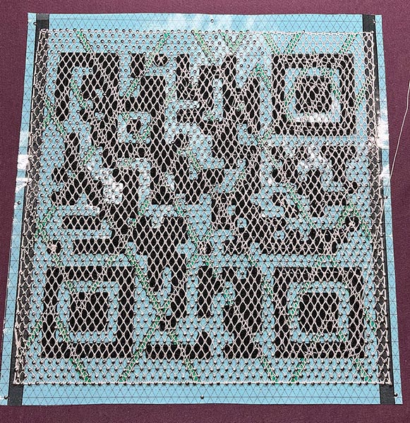 Bobbin Lace background and needle lace QR code being sewn together.