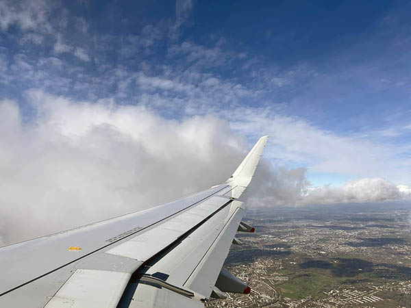 Airplane wing and clouds out of an airplane window.