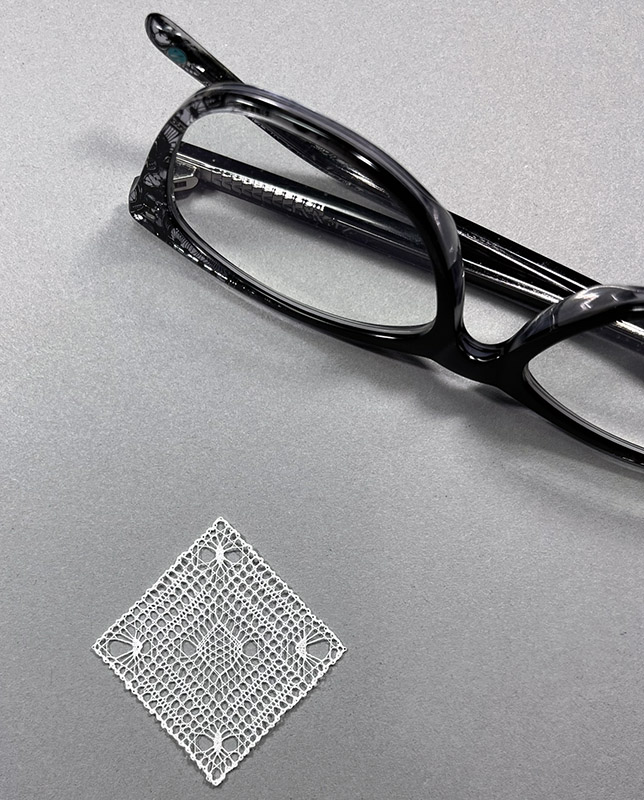 Reading glasses as a size reference for the tiny lace. 