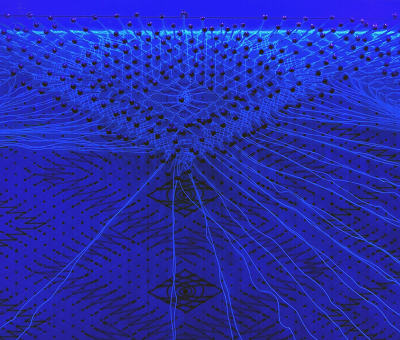 The blacklight shows the first finished diamond-shaped cloth stitch trail.