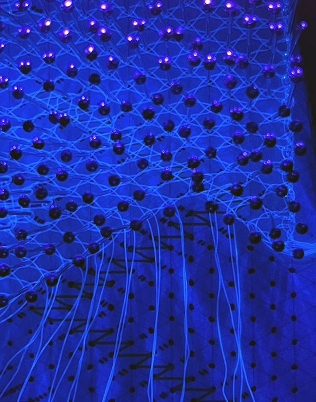 Close view of a thin half stitch trail under blacklight.